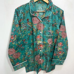 My Include : A Green Floral Patterned Night suit (Pyjama set) A Long Sleeve Shirt and Matching Pants. The Shirt Has a Pocket with White Piping.