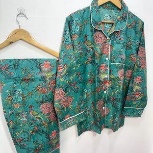 My Include : A Green Floral Patterned Night suit (Pyjama set) A Long Sleeve Shirt and Matching Pants. The Shirt Has a Pocket with White Piping.