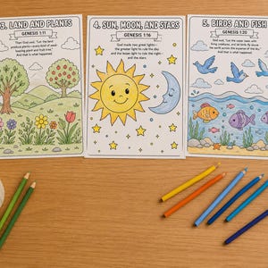 Op de afbeelding: Drie kleurplaten met illustraties van land en planten, zon, maan en sterren, en vogels en vissen. Elke pagina bevat tekst uit Genesis. Gekleurde potloden liggen verspreid rond de pagina's.