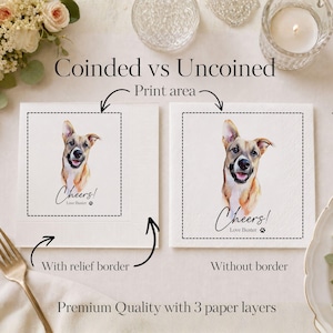 Op de afbeelding: Twee witte papieren servetten met een aquarelillustratie van een bruin-witte hond. Het linker servet heeft een reli&euml;frand, terwijl het rechter servet glad is. Beide servetten tonen de tekst Cheers! Love Buster met een pootafdruk.