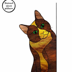 May include: Stained glass pattern of a brown and yellow cat with green eyes, looking over its shoulder, against a brown background.
