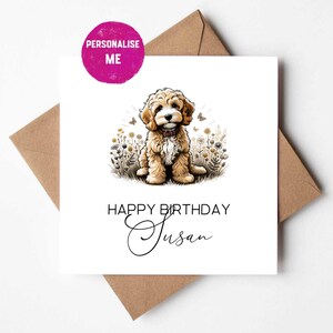 Könnte beinhalten: Eine quadratische Grußkarte mit einer Illustration eines braun-weißen Doodle-Welpen, der in einem Feld mit Wildblumen und Schmetterlingen sitzt. Die Karte zeigt den Text HAPPY BIRTHDAY Susan und ein rosa Abzeichen mit PERSONALIZE ME.