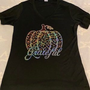 May include: Black t-shirt with a rainbow rhinestone pumpkin and the word "Grateful" in rhinestones.