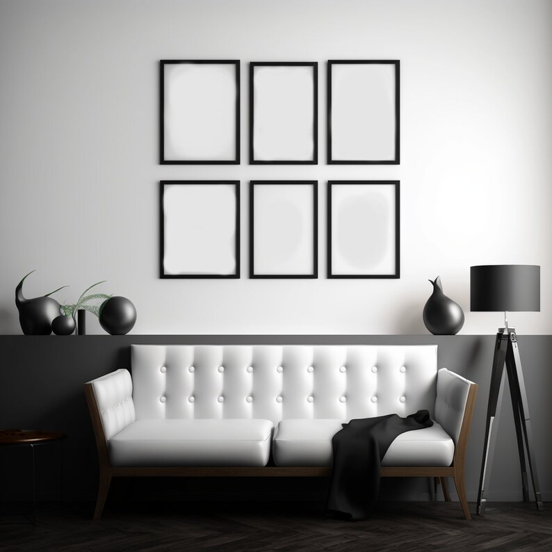 Puede incluir: Un sof&aacute; blanco con una manta negra en una sala de estar moderna con una pared de galer&iacute;a en blanco y negro de seis impresiones enmarcadas y una l&aacute;mpara de pie negra.