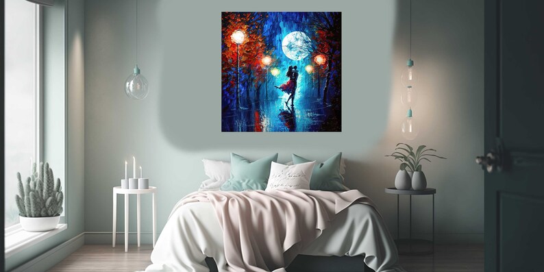 May include: A square canvas painting depicts a couple dancing under a full moon in a rainy, illuminated street scene. The artwork features vibrant blues, reds, and oranges, with the couple's silhouettes in the foreground. The painting hangs above a bed with a light pink blanket.