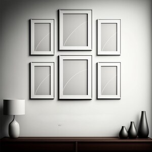 Puede incluir: Una pared blanca con seis marcos de fotos blancos dispuestos en forma de cuadr&iacute;cula. Los marcos est&aacute;n vac&iacute;os y tienen una sutil l&iacute;nea blanca en el centro. Debajo de los marcos hay una estanter&iacute;a de madera marr&oacute;n con tres jarrones negros. Una l&aacute;mpara blanca se encuentra en la estanter&iacute;a a la izquierda de los jarrones.