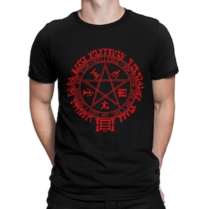 Puede incluir: Camiseta negra con un pentagrama rojo y texto en un círculo a su alrededor. El texto incluye "Hellsing", "Gott Mit Uns", y "And Shine Heaven", entre otras palabras. El pentagrama tiene los caracteres japoneses para "Seis", "Uno", "Cinco", y "Tres" dentro de él. El número "812" está debajo del pentagrama.