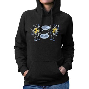 May include: Black hooded sweatshirt with a front pocket. The graphic features two cartoon atoms with speech bubbles that read "I lost an electron" and "Are you positive?"