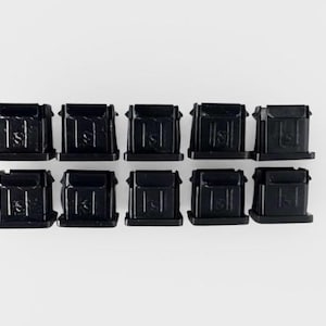 May include: Ten black plastic rectangular components with a small, raised design on the front. The components are arranged in two rows of five against a white background. The items appear to be new.