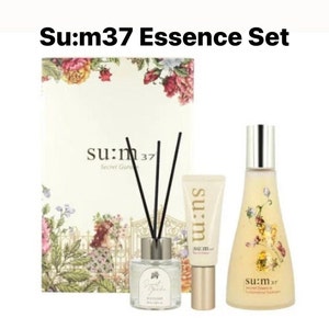 May include: A set of Su:m37 skincare products in a white box with floral designs. The set includes a bottle of facial treatment essence, a tube of facial cream, and a diffuser with black sticks.