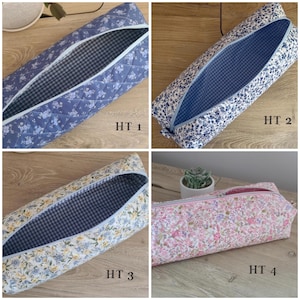 May include: Four rectangular fabric pencil cases with zippered openings. HT 1 is quilted blue with white flowers and a black gingham lining. HT 2 is blue floral with a blue gingham lining. HT 3 is yellow and blue floral with black gingham. HT 4 is pink floral.