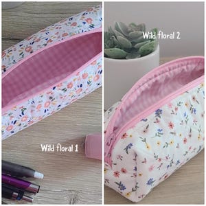 Puede incluir: Dos estuches acolchados con base de tela blanca y un colorido estampado floral de peque&ntilde;as flores rosas, azules y amarillas. Los estuches tienen una cremallera rosa y un forro interior de cuadros vichy rosa y blanco. Etiquetas Wild floral 1 y 2.