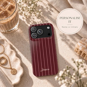 May include: A deep burgundy smartphone case featuring thin vertical white pinstripes and the name Jessica written in a white cursive script at the bottom. The case has a black camera module cutout with three circular lenses and a flash.