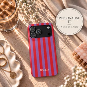 May include: A rectangular smartphone case featuring vertical red and purple stripes with the name JESSICA printed in white near the bottom. The case has a black camera module cutout at the top with three circular lenses and a small flash component.