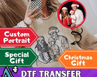 May include: A beige sweatshirt with a custom family portrait design. The image includes a family portrait in a red circle and a line drawing of a family. Text includes "Custom Portrait", "Special Gift", "Christmas Gift", and "DTF Transfer Ready to Press".