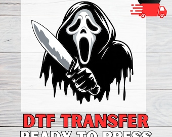 May include: A black and white graphic of the Ghostface character from the Scream horror film franchise, holding a large knife. The text "DTF TRANSFER READY TO PRESS" is displayed in red at the bottom of the image.