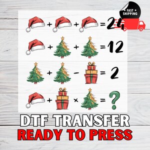 May include: A DTF transfer design featuring Christmas-themed math equations with Santa hats, Christmas trees, and gift boxes. The text "DTF TRANSFER READY TO PRESS" is displayed below the equations. A red truck with the words "FAST SHIPPING" is in the upper right corner.