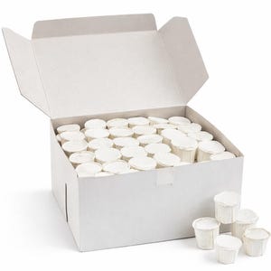 Puede incluir: Una caja de cartón blanca abierta, llena de numerosas tazas de papel blancas pequeñas. Algunas tazas están apiladas fuera de la caja. Las tazas parecen ser desechables y probablemente sean para un solo uso.