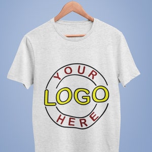 May include: A gray t-shirt with a black circle and the text "YOUR LOGO HERE" in red and yellow.