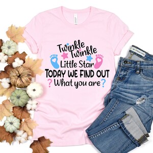 May include: Pink t-shirt with the text "Twinkle Twinkle Little Star Today We Find Out? What you are?" with blue and pink footprints and stars.