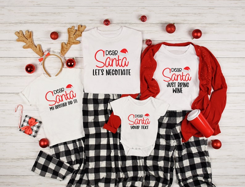 May include: A family of four matching Christmas pajamas with a black and white plaid pattern. The shirts feature the text "Dear Santa" with different messages. The adult shirts say "Let's Negotiate" and "Just Bring Wine". The child's shirt says "My Brother Did It!" and the baby's shirt says "Your Text".