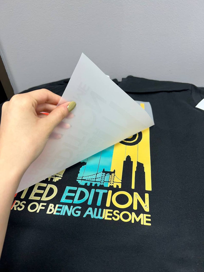 May include: A black t-shirt with a colorful graphic design featuring a cityscape and the text "Limited Edition 10 Years of Being Awesome".