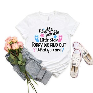 May include: White t-shirt with the text "Twinkle Twinkle Little Star Today We Find Out? What you are?" with blue and pink footprints and stars.