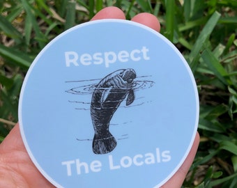 Pode incluir: Um adesivo redondo azul e branco com uma ilustração em preto e branco de um peixe-boi. O adesivo diz "Respect The Locals".