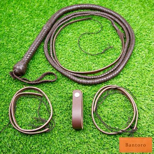 May include: A dark brown leather whip with a braided handle and multiple strands, along with two leather loops and a leather strap. The items are arranged on a green surface. The word "Bantoro" is printed on a small orange rectangle.