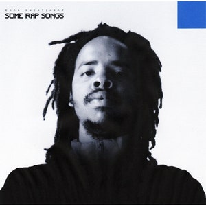 May include: Album cover for "Some Rap Songs" by Earl Sweatshirt. The image features a black and white portrait of a man with dreadlocks. The album title and artist name are printed in a sans-serif font. A blue square is in the upper right corner.