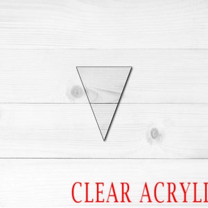May include: A clear acrylic triangle shape on a white wood background. The text "CLEAR ACRYLIC" is printed in red below the triangle.
