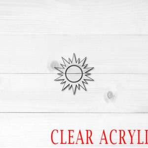 May include: A clear acrylic sun cutout with a white wood background. The text "CLEAR ACRYLIC" is printed in red below the sun.