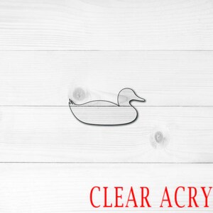 May include: A simple outline of a duck in a swimming position, cut from clear acrylic.