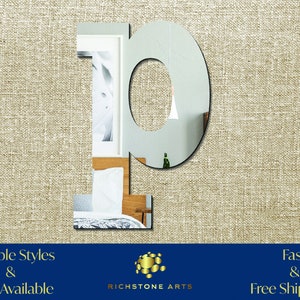 May include: A silver mirror letter P, with a slightly rounded top, is displayed against a beige textured background. The letter is large and reflective, with a slight distortion of the background visible in the reflection. The text "Multiple Styles & Sizes Available" is at the bottom left of the image, and "Fast & Free Shipping!" is at the bottom right. The text "RICHSTONE ARTS" is centered below the letter.