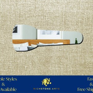 May include: A silver-colored, elongated, abstract mirror with a rounded edge. The mirror reflects a bedroom with a wooden headboard and pillows. The text "Multiple Styles & Sizes Available" is in the lower left corner of the image. The text "Fast & Free Shipping!" is in the lower right corner of the image. The text "RICHSTONE ARTS" is in the center of the image.