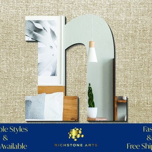 May include: A large, mirrored letter "n" in a modern, minimalist style. The mirror reflects a room with a bed, a plant, and a light fixture. The text "Multiple Styles & Sizes Available" and "Fast & Free Shipping!" is displayed at the bottom of the image.