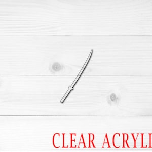 May include: A clear acrylic sword silhouette on a white wood background. The text "CLEAR ACRYLIC" is printed in red below the sword.