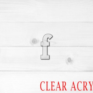 May include: A wooden letter "f" in a light color is centered on a white wooden background. The text "CLEAR ACRYLIC" is printed in red at the bottom of the image. The letter is made of wood.