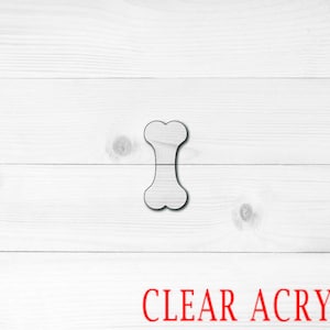 May include: A white bone-shaped cutout made of clear acrylic.