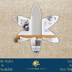 May include: A star-shaped mirror with a white background. The mirror is reflecting a bedroom with a bed, pillows, and two framed black and white photos. The text "RICHSTONE ARTS" is visible below the mirror.