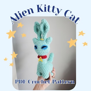 May include: A turquoise crocheted Alien Kitty Cat with large ears, blue eyes, and a red collar with a yellow letter "A". The text "Alien Kitty Cat" and "PDF Crochet Pattern" are displayed on a light blue background with yellow star accents.