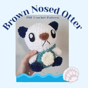 May include: A handmade crochet otter plushie with a white body, dark blue ears and feet, and a brown nose. The otter wears a teal and white vest. Text on the image reads "Brown Nosed Otter PDF Crochet Pattern."