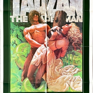 Może przedstawiać: Plakat filmowy do filmu "Tarzan, człowiek małpa" z Bo Derek i Richardem Harrisem. Plakat przedstawia scenę dżungli z Tarzanem trzymającym kobietę związaną lianami.