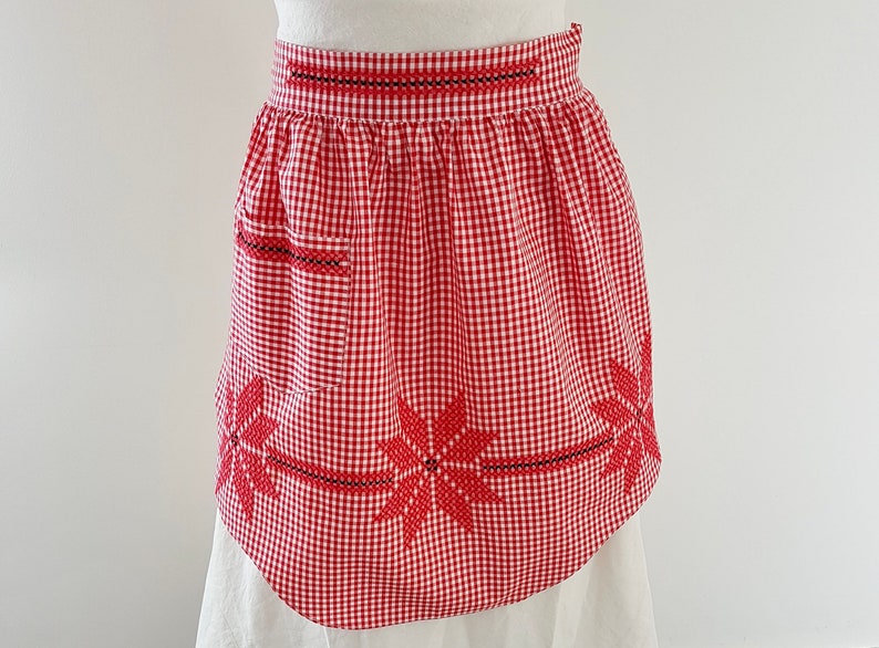 vintage circa 1950s Domestic Goddess Half Apron, Red and White Gingham with embroidery detail and one pocket. In excellent vintage condition. 
One Size. Width across the top 42cm plus ties, length through centre 52cm each fabric tie is 49cm long.