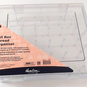 May include: Clear plastic thread organiser with a hinged lid. The organiser holds 30 mini cones or spools up to 70mm in height. The label reads "Tall Box Thread Organiser" and includes dimensions of 295mm x 250mm x 85mm.