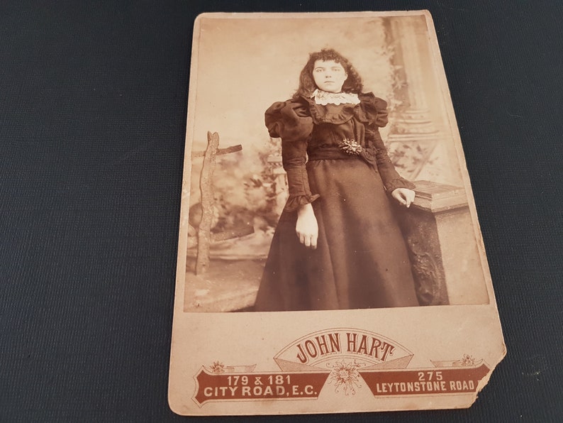 Antique mid to late victorian sepia photograph with decorative back. A young lady with ringlet hair in high victorian clothing and leg o mutton sleeves. Lower front printed with John Hart Leystone Rd London In excellent condition
Size 10.5cm x 16.5cm