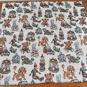 May include: A white fabric with a repeating pattern of colourful cartoon animals and toys. The animals include lions, rabbits, and turtles. The toys include a stack of rings, a rocking horse, and a toy car. The fabric is woven with a textured surface.