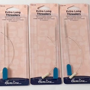 Könnte beinhalten: Fünf Packungen Extra Long Einfädler für Overlock- und Nähmaschinen. Jede Packung enthält einen Nadeleinfädler mit blauem Griff und weißer Spitze. Der Markenname Hemline ist unten auf jeder Packung aufgedruckt.