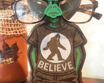 Unique Alien Eyeglass Holder – Handcrafted Wooden Extraterrestrial Wearing a Bigfoot Believe T-Shirt Glasses Stand