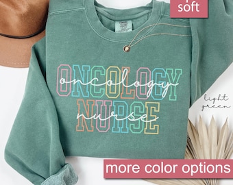 May include: A light green sweatshirt with the text "ONCOLOGY NURSE" in rainbow colors. The sweatshirt is super soft and has more color options.
